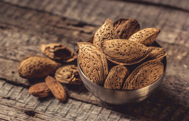 Almond nuts in shell close-up on a wooden background