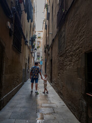 Fototapeta na wymiar father and son stroll hand in hand down a narrow street