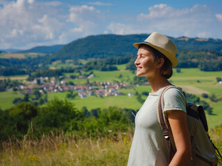 Fototapeta premium travel to summer Europe young asian woman. observation point above the village of Roggenburg, Switzerland. hike in summer forest, having a break