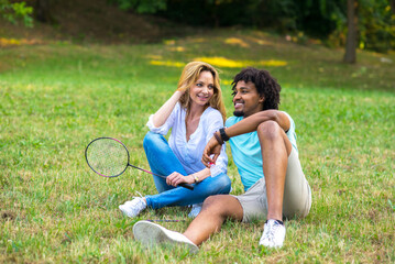 Fototapeta premium Young mixed race couple playing badminton on a summer meadow 