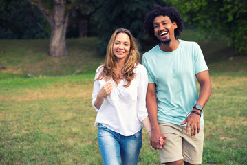 Young mixed race couple walking in the summer nature	