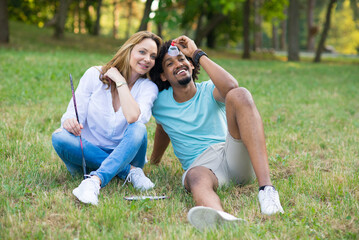 Young mixed race couple playing badminton on a summer meadow	