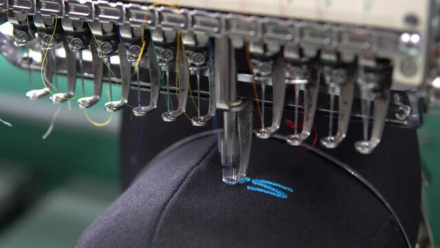 Embroidery machine in progress embroidery company logo on uniform in Textile Industry at Garment Manufacturers.