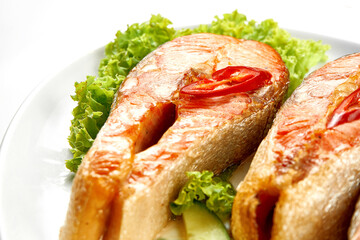 Salmon steaks in a white plate on a white background. Close-up, selective focus
