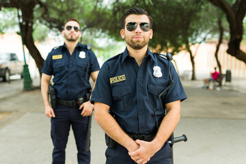 Caucasian cops on duty standing outdoors in the park