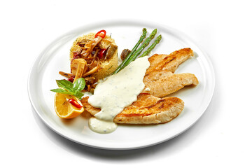 Fried fish fillet with white sauce and couscous. Close-up, selective focus