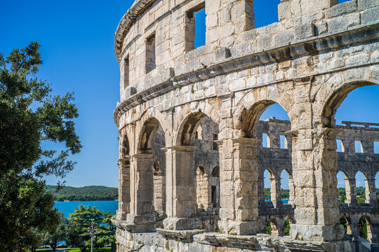Roman amphitheater in the city of Pula, Croatia. Close-ups on the ancient walls of a Roman building. A beautiful sunny day with fairy-tale clouds in the background