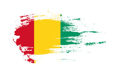 Grunge brush stroke flag of Guinea with painted brush splatter effect on solid background