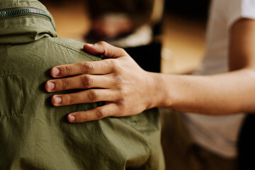 Hand of young supportive man consoling his friend or one of attendants with post traumatic syndrome...