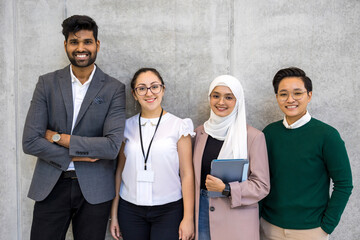 Shot of a small diverse group of businesspeople standing against a grey wall