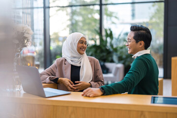 Young business couple using laptop in the office
