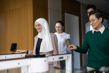 Obraz premium Young&nbsp;business people entering their workplace through security turnstiles 