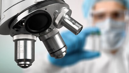 Man scientist with new steel microscope at laboratory.