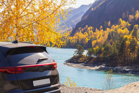 Rear View Of Black Car, Parked In Rest Area Or Lookout Road, Mountain Blue River Backdrop.