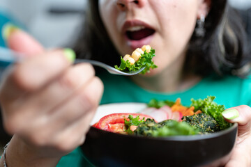 Woman eating veggie lunch. Vegetarian and plant based food concept. Selective focus,