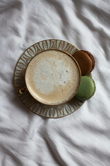 morning coffee with macaroons on sheets. coffee in bed