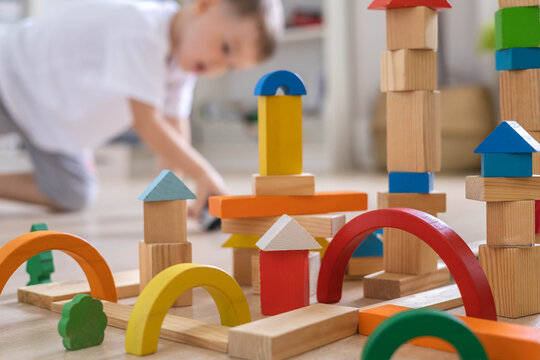 Confident male kid building fortress tower architecture wooden bricks ecology Montessori material