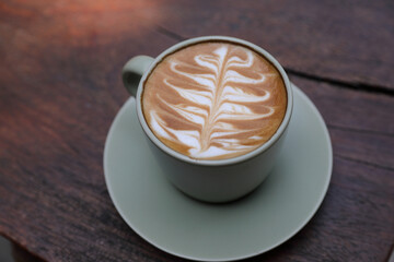 hot cappuccino with latte art on wood background