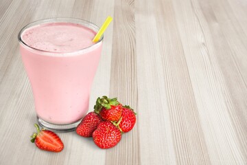 Tasty sweet milk smoothie with strawberry on the table