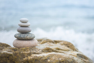 Fototapeta na wymiar Pebble tower balance harmony stones arrangement on sea beach coastline peaceful formation pyramid
