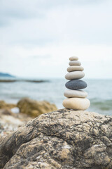 Fototapeta premium Pebble tower balance harmony stones arrangement on sea beach coastline peaceful formation pyramid