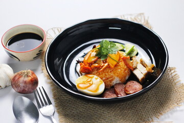 rice with roasted pork on top served with cucumber, boiled egg, crispy pork and bbq sauce that are sold in many places in Thailand.Barbecued red pork in sauce with rice is a popular food in Thailand.