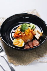 rice with roasted pork on top served with cucumber, boiled egg, crispy pork and bbq sauce that are sold in many places in Thailand.Barbecued red pork in sauce with rice is a popular food in Thailand.