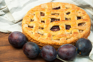shortcake with plums on a wooden table. the concept of homemade shortcrust pastry. baked fruit dessert on the kitchen table close up
