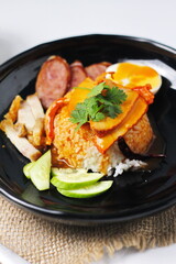 rice with roasted pork on top served with cucumber, boiled egg, crispy pork and bbq sauce that are sold in many places in Thailand.Barbecued red pork in sauce with rice is a popular food in Thailand.
