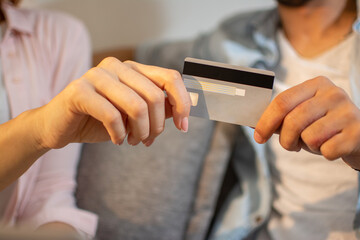 Close up of male and female hands holding bank card together. Man and woman holding credit card in hands together.