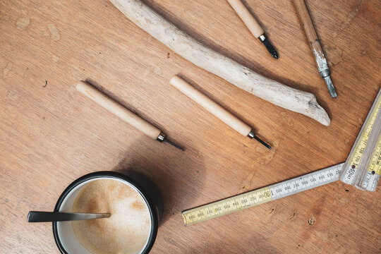 Wooden Table With Coffee And Driftwood From Beach And Craft Utensils 