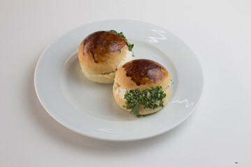 2 roll cheese and parsley buns isolated on a round white plate