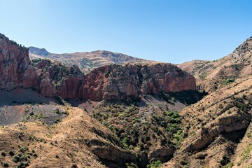 Fototapeta na wymiar Red rocks among the mountain landscape in the mountains of Armenia.