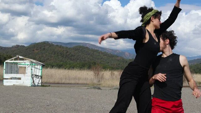 A woman and a man dance contact improvisation in nature. physicality in dance.