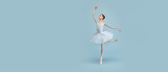 Portrait of tender young ballerina dancing, performing isolated over blue studio background. Flyer