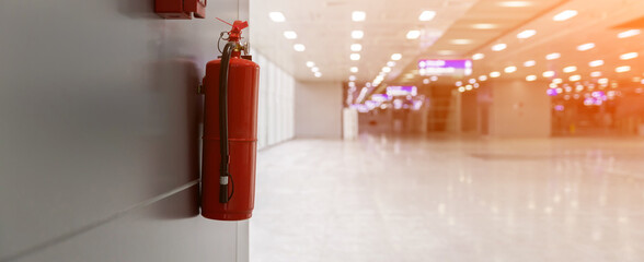 Dry chemical powder fire extinguisher in corridor. Install a fire extinguisher on the wall in...