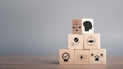 Ethics inside human mind, Business ethics concept. Ethics inside a head symbols in wooden cubes stacked on gray background with copy space. - obrazy, fototapety, plakaty