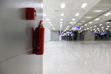Dry chemical powder fire extinguisher in corridor. Install a fire extinguisher on the wall in...