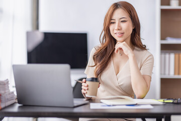 Portrait of Young Asian businesswoman is happy to work at the modern office using a laptop computer, freelance business employee online marketing e-commerce telemarketing concept.