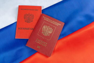 Russian foreign passport and military id serviceman of  citizen of the Russian Federation on Russian flag. Translation: Passport, Military ID card, Russian Federation.
