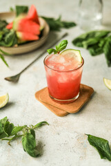 Refreshing healthy non-alcoholic drink with ice, watermelon, lime and basil leaves
