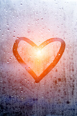 Autumn rainy weather. Drawing on the window: Heart. Finger drawing on the misted glass