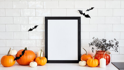 Black picture frame mockup with pumpkins, Halloween home decor, vase of flowers on table in...
