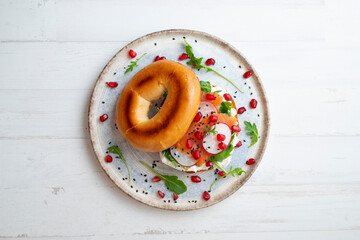 Toasted baggels with salmon, cream cheese, arugula, radishes and pomegranates.