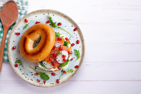 Toasted baggels with salmon, cream cheese, arugula, radishes and pomegranates.