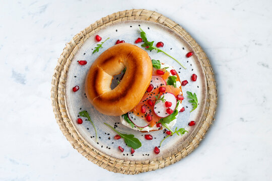 Toasted baggels with salmon, cream cheese, arugula, radishes and pomegranates.