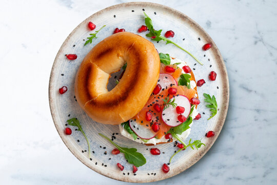 Toasted baggels with salmon, cream cheese, arugula, radishes and pomegranates.