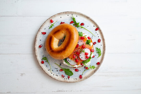 Toasted baggels with salmon, cream cheese, arugula, radishes and pomegranates.