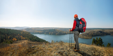 Travel hiking man hiker on trek hike with backpack, hiking poles. Active lifestyle people outdoor sports. Banner with copy space.