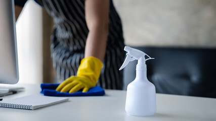 Person cleaning the room, the cleaner is wiping the desk in the company office. Cleaning staff....